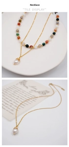 Detail of layered beaded necklace set featuring colorful stones and baroque pearl pendant