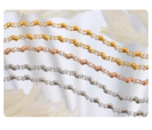 Trois colliers ondulés en acier inoxydable finitions or, or rose et argent poli