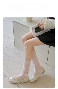 Detailed close-up of pink knit slouch socks paired with pearl-decorated Mary Jane shoes