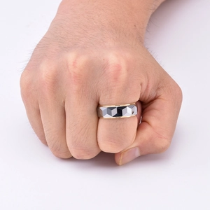 Vue détaillée d'une bague facettée en acier tungstène bicolore avec bords dorés pour homme