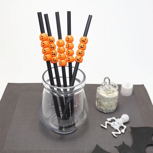 Halloween straws in a glass jar featuring orange pumpkin heads and spooky party decor
