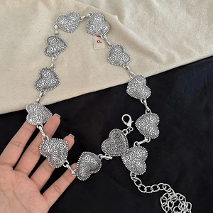 Detail der silbernen Herz-Metall-Taillenkette mit Vintage-Gravuren und Karabinerverschluss