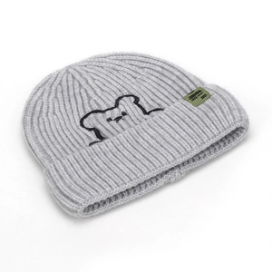 Detailed view of grey knitted beanie featuring black bear embroidery and green woven label