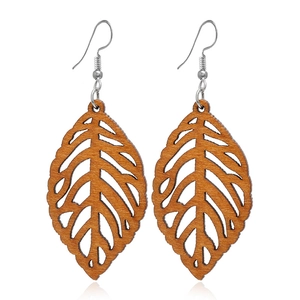 Détail de boucles d'oreilles en bois marron en forme de feuille avec des veines gravées