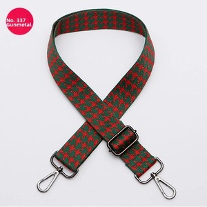 Close-up of adjustable houndstooth shoulder strap in red and green with gunmetal hooks