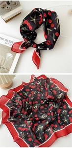 Detail of cotton linen scarf featuring red cherry print and floral patterns with woven texture