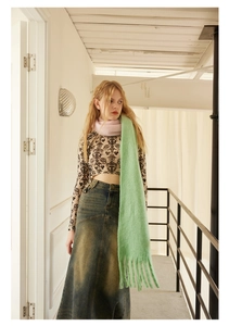 Close-up of soft light green wool blend scarf with fringe tassels for winter style