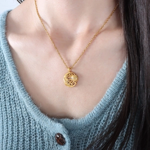 Vintage gold sun and moon pendant necklace with star details worn by a model