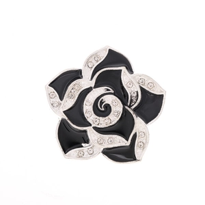Black enamel camellia brooch with crystal inlays on a clean white background