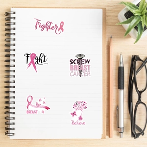 Pink ribbon stickers with fighter and believe text on a notebook for breast cancer awareness