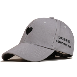 Close-up of grey baseball cap featuring heart embroidery and slogan love her but leave her wild