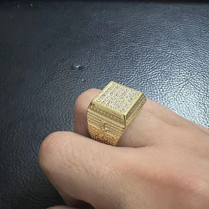 Close-up of gold-plated hip hop ring with square face and micro-pave cubic zirconia