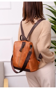 Close-up of vintage brown PU leather backpack with back vertical anti-theft zipper detail