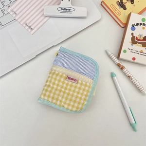 Close-up of quilted fabric organizer bag with blue stripes and yellow checkered patterns