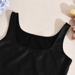Detalle de los tirantes del crop top negro con cuello en U y textura mate suave