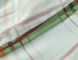 Macro view showing the detailed stitching and plaid twill fabric texture of the suit