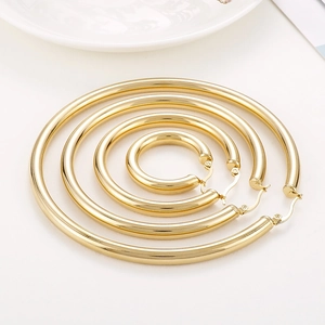 Four pairs of various sized 18K gold plated stainless steel chunky hoop earrings on white