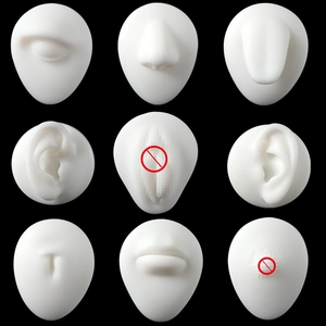 Nine-piece white silicone body piercing training models on a professional black background
