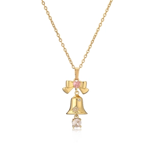 Collier de Noël doré avec pendentif cloche, gemme cœur rose et nœud sur fond blanc