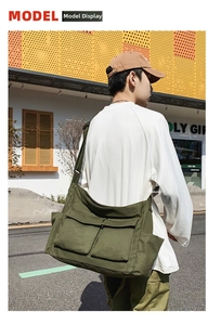 Detail of army green canvas crossbody bag featuring large front flap pockets