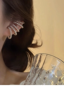 Detail view of a multi-layer pearl ear cuff on a model for an elegant non-pierced look