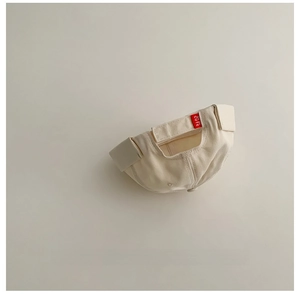 Dettaglio della chiusura in velcro regolabile con etichetta CUTE sul cappello bimbo