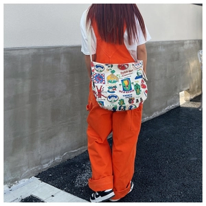 Back view of a white canvas crossbody bag with vintage American cartoon print on a model