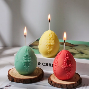 Detailed relief patterns on pastel Easter egg candles placed on a rustic wood base