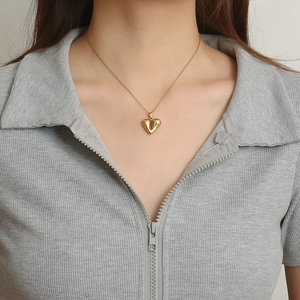 Polished 18K gold-plated heart pendant necklace worn on a female model with sleek chain