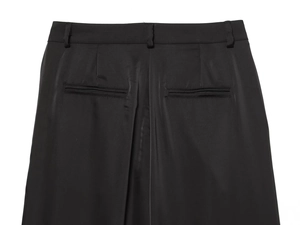 Close-up of black satin trousers featuring rear welt pockets and standard belt loops