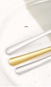 Detail of thickened stainless steel handles in gold and silver with polished finish