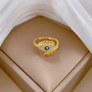 Adjustable gold evil eye ring with pavé diamonds and blue crystals on a velvet box
