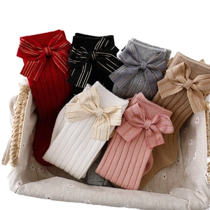 Kids knitted knee-high socks with gold-lined bows in red, black, and neutral colors