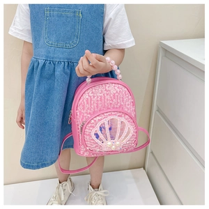 Close-up of pink sequin shell backpack featuring a pearl handle and transparent detail