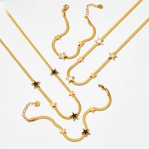 Detailed view of gold snake chain set with black and white star pendants on flat links