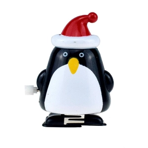 Detail of penguin clockwork toy with red Christmas hat and side winding mechanism