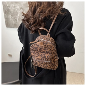 Detail view of mini leopard print backpack with silver hardware on a black coat