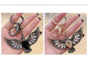 Detail showing vintage eagle keychains in gunblack and gold finish with inset stones