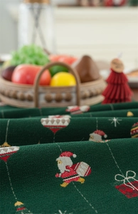 Close-up of green jacquard table runner showing festive Santa and gift box textures