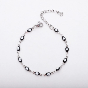 Minimalist silver stainless steel bracelet featuring black and white evil eye charms and clasp