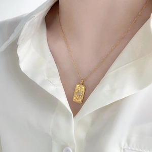 Detail of 18K gold plated titanium pendant featuring The World tarot card on a fine chain