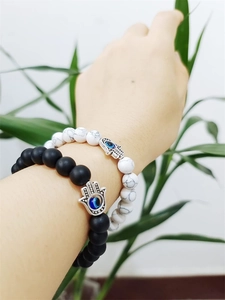 Macro shot of natural stone beaded bracelets with silver Hamsa Hand and Evil Eye charms