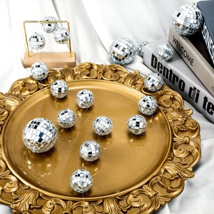 Silver mirror disco ball set of various sizes on a golden tray for party decorations
