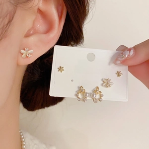 Close-up of three pairs of S925 silver needle earrings with floral and butterfly motifs