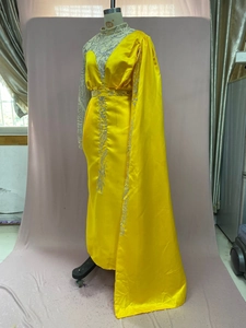 Detail van de gele satijnen avondjurk met zilveren pailletten en een een-schouder cape