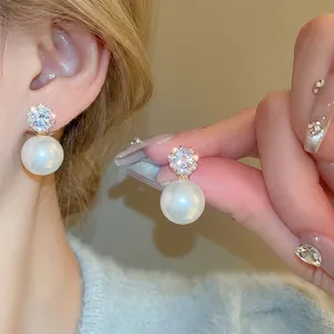Elegant silver pearl earrings with sparkling zircon clusters shown in a close-up lifestyle shot
