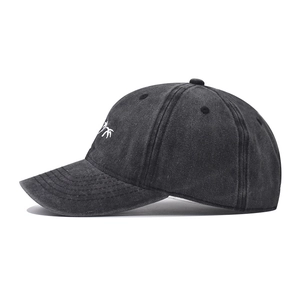Détail de broderie de quatre cocotiers sur casquette de baseball noire délavée vieillie
