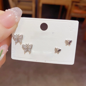 Detailed view of silver butterfly stud earring set with sparkling stones on card