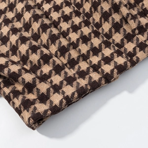 Close-up of premium houndstooth tweed fabric texture in classic brown and beige tones