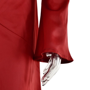 Detail of red satin dress featuring elegant flare sleeves and high-gloss fabric texture